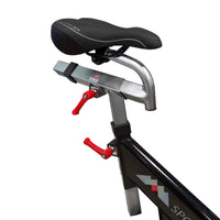 M Sport indoor studio exercise bike with adjustable seat and handlebars, designed for indoor cardio workouts.